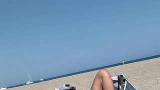 She masturbates her on the naturist beach in public with a voyeur who passes by