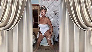 Hot housewife Lukerya flirts in her white lingerie at home in the kitchen.