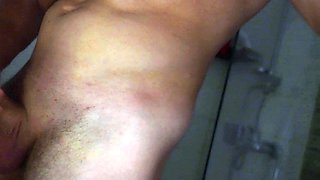 A muscular guy shows his dick in the shower