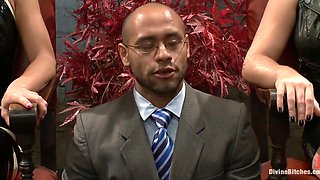 Two sexy dominatrixes play with a bouded guy's cock and pound his ass with a strapon