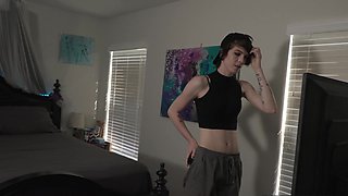 A young cute girl in a black dress, smiling, showing her breasts.