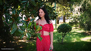 Sultry Brunette in Red Dress Smoking Rolled Cigarette